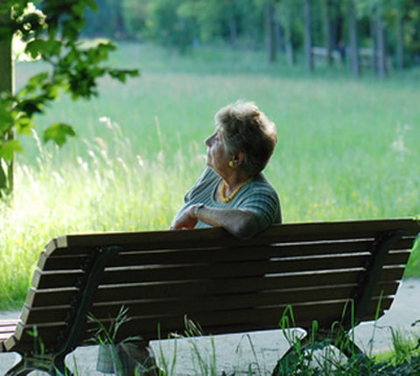 Personne âgée atteinte de troubles neurologiques avancés recevant un soutien d’un proche dans un environnement de soins.